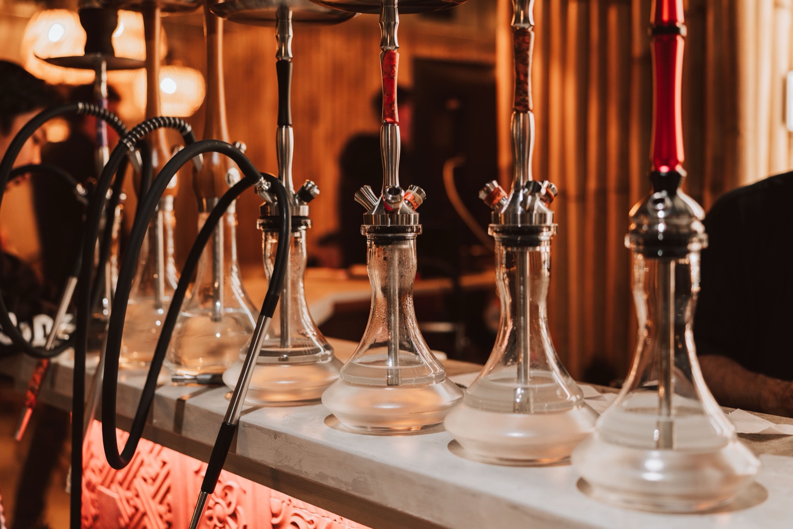 A row of glass-base shisha pipes lined up at Komodo Lounge