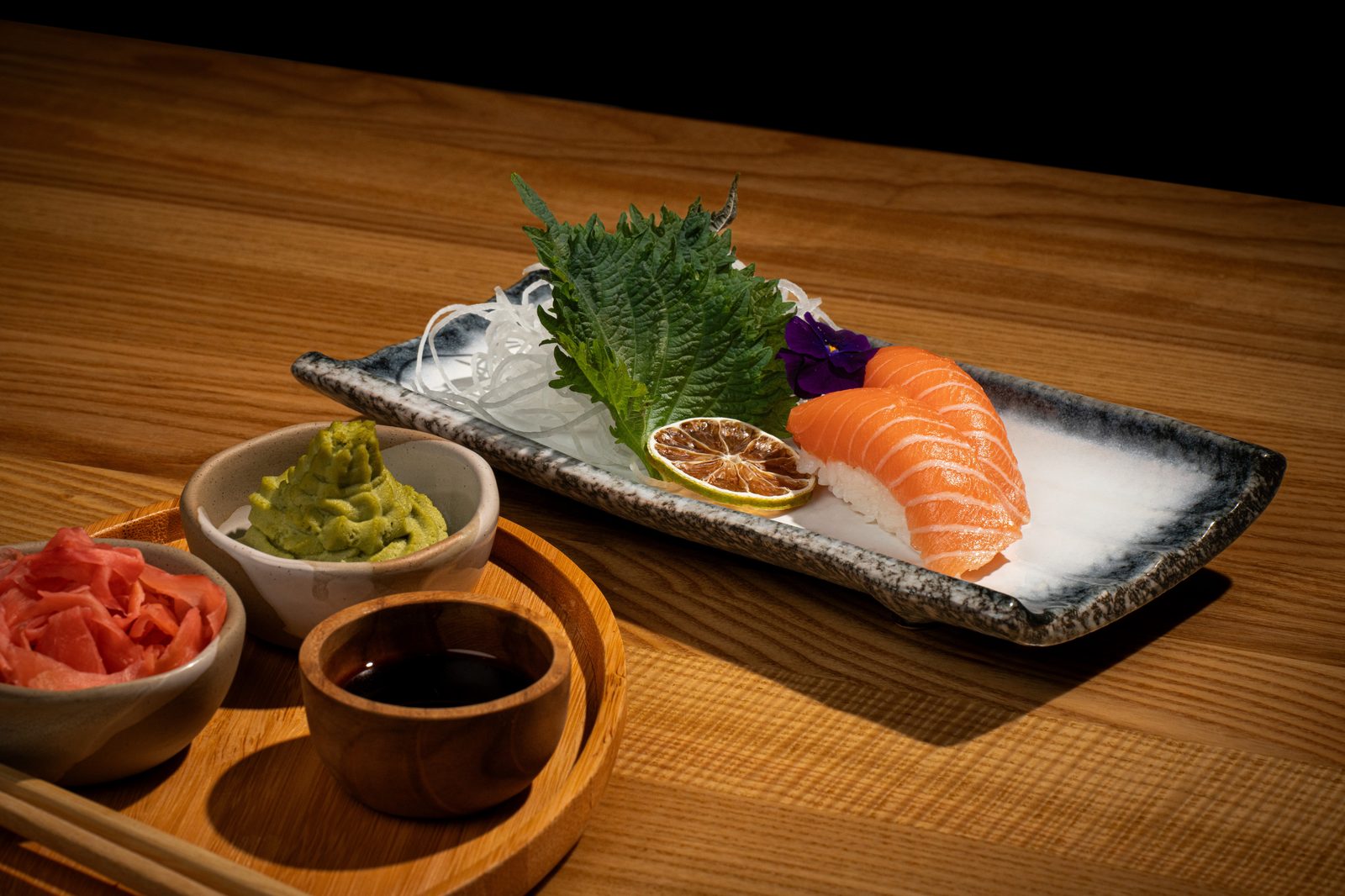 Salmon sashimi on shiso leaf with daikon and citrus