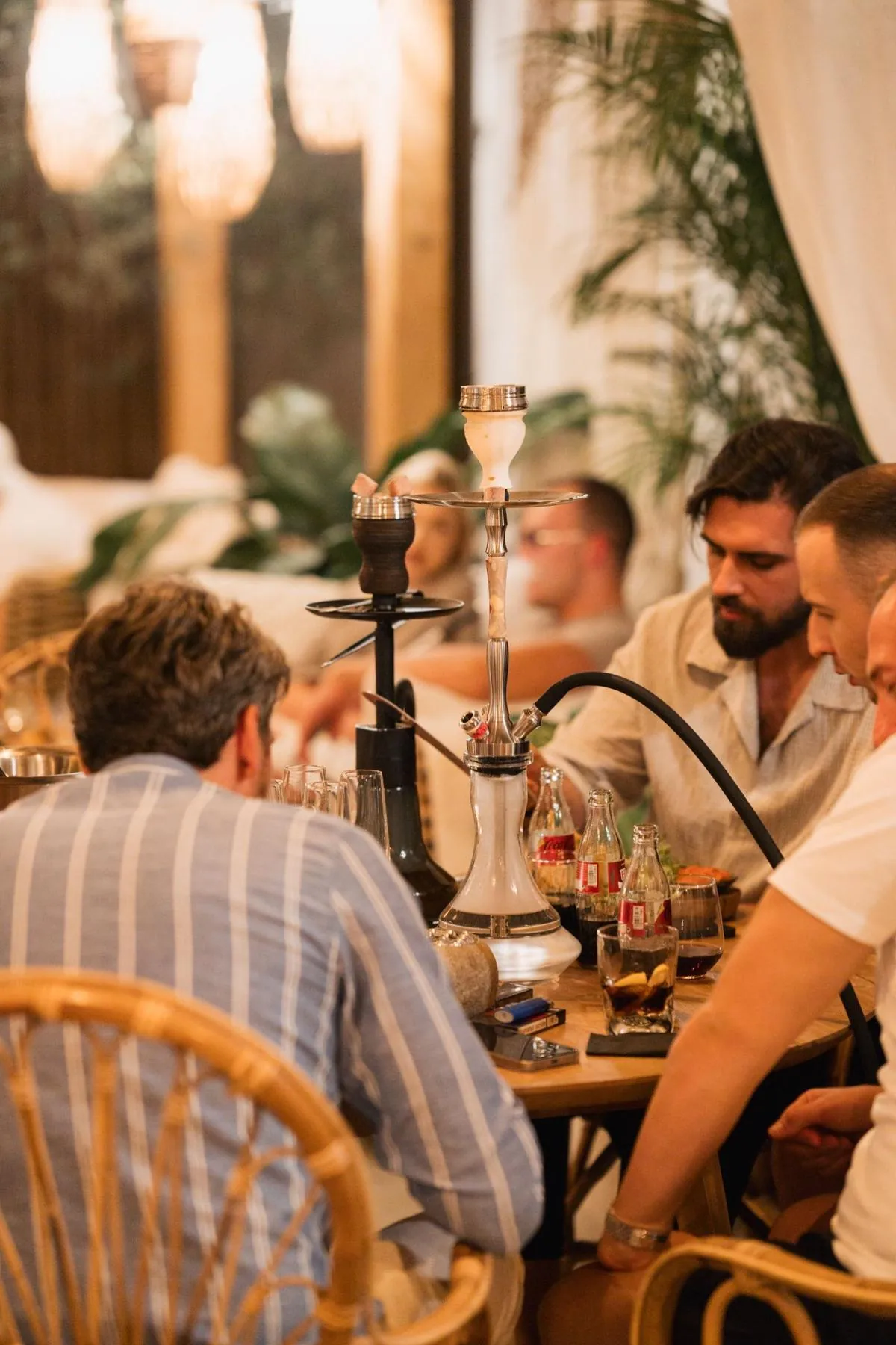 Group around a glass hookah with drinks on the table at Komodo Lounge