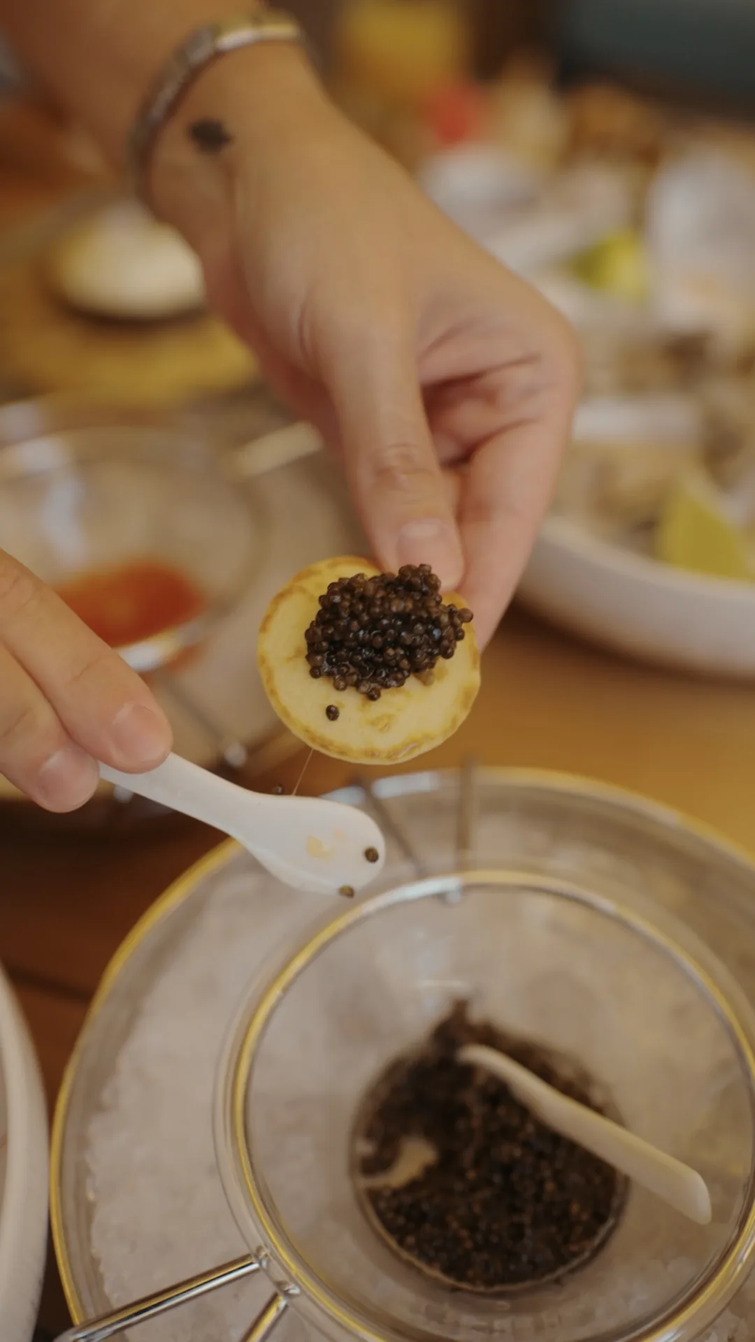 Caviar negru asezat cu lingura de sidef pe un blini