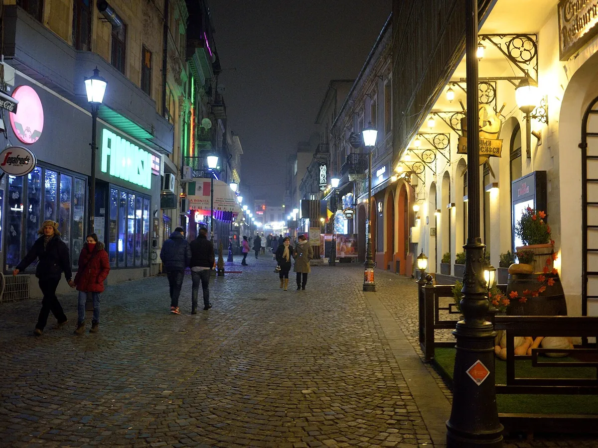 Oameni în paltoane în Centrul Vechi, noaptea