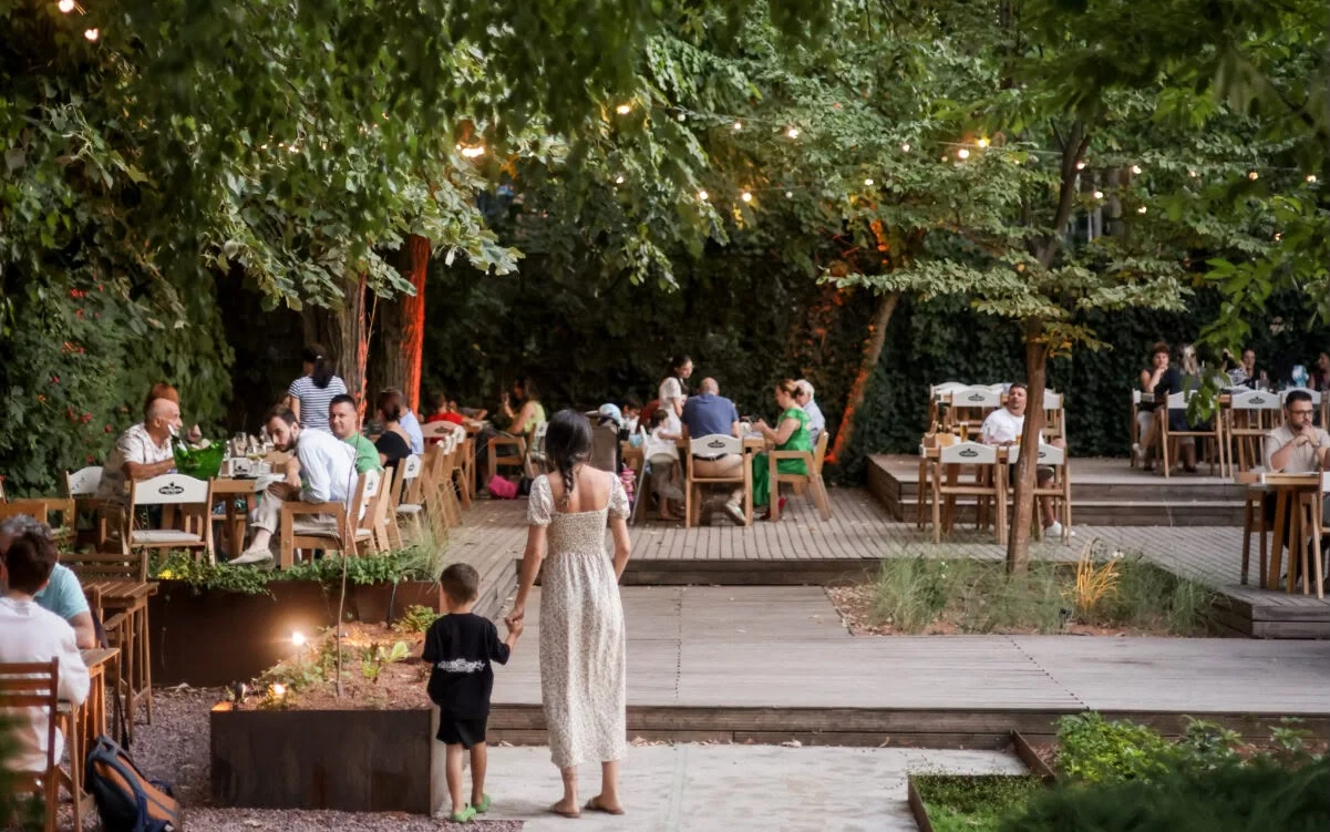Gradina Floreasca — mese sub copaci si lumini calde, seara