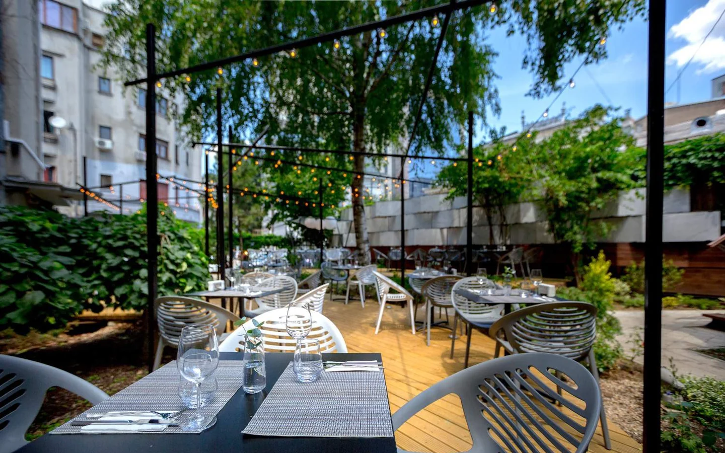 Restaurant Savart — terasa cu mese aranjate si ghirlande de lumini
